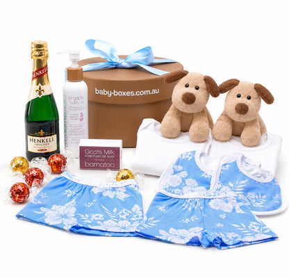 Baby gift set with Henkel champagne, baby clothes, and toys on a white background